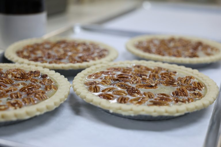 Four pecan pies on baking trays. Bakery items made on site. Contact Yoder's Country Market today!