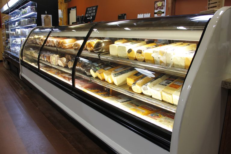 Deli case showcasing a wide selection of cheese and meat